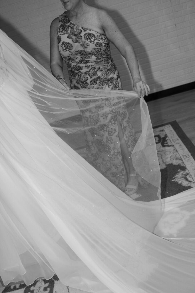 mom helping bride with dress